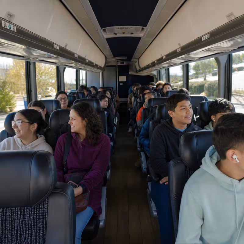 Group boarding a white charter bus for School Transportation transportation in Carrollton