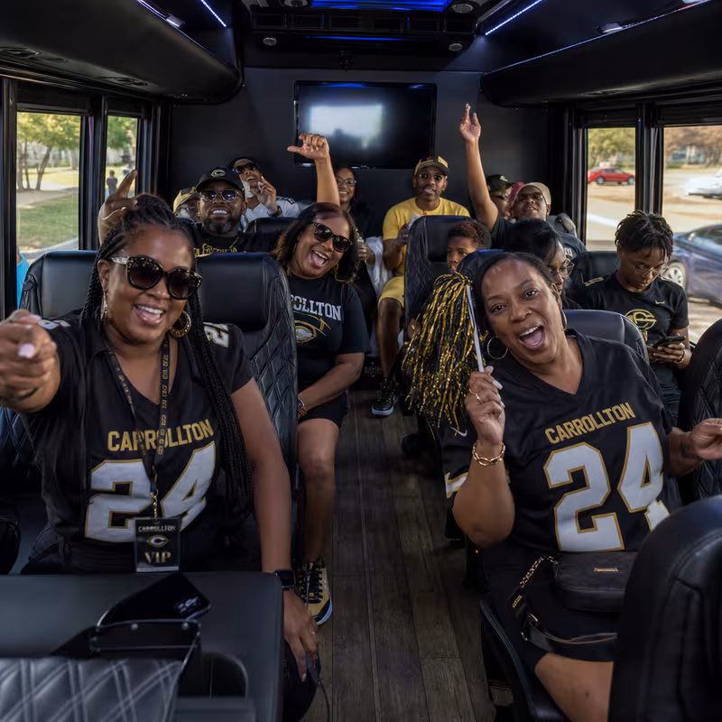 Group boarding a white charter bus for Sporting Event Transportation transportation in Carrollton