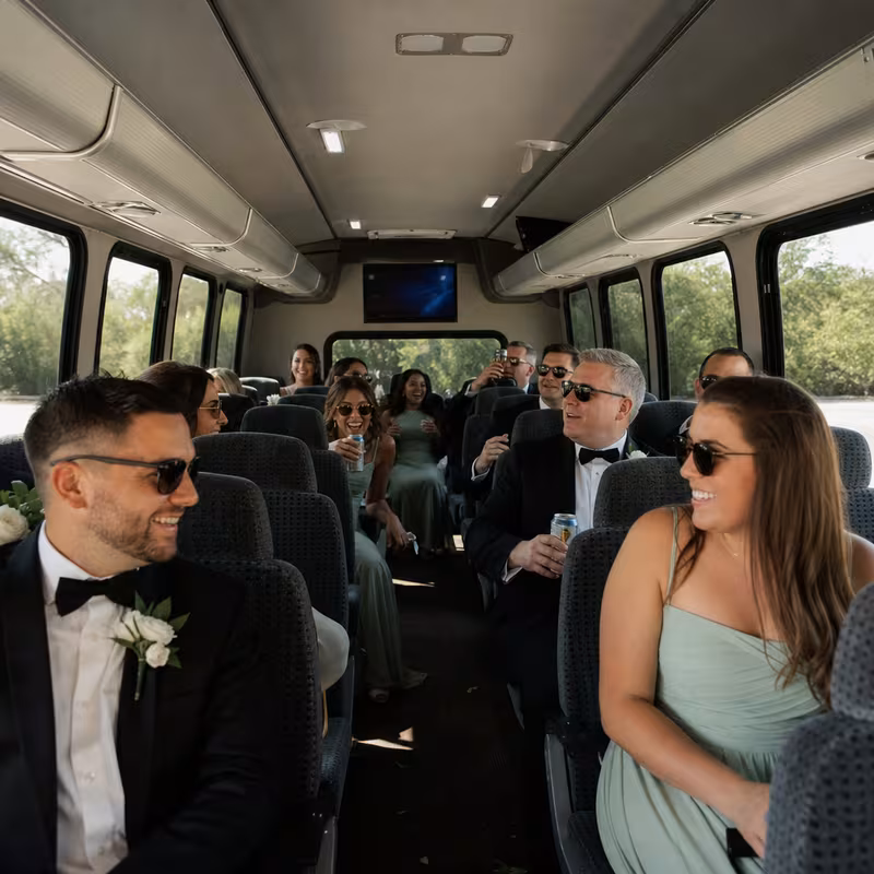 Group boarding a white charter bus for Wedding Transportation transportation in Carrollton